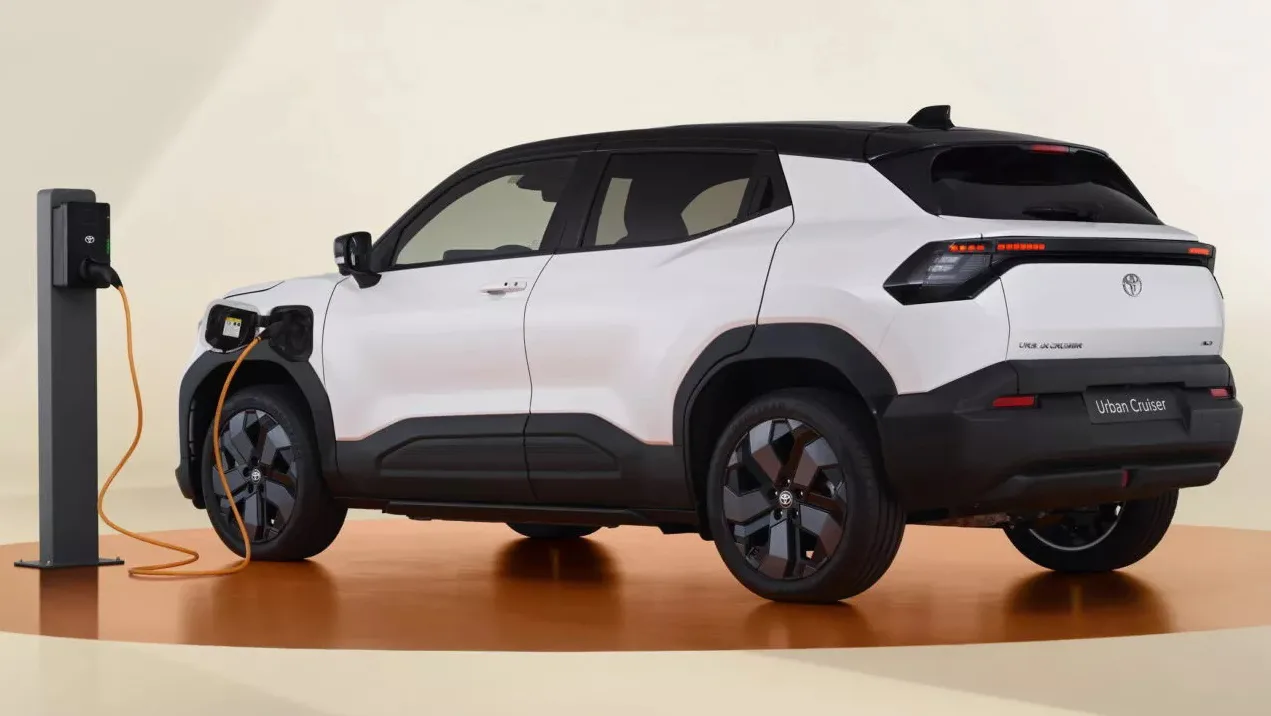 Toyota Urban Cruiser branco com partes pretas sendo recarregado, com tomada escura e fundo branco