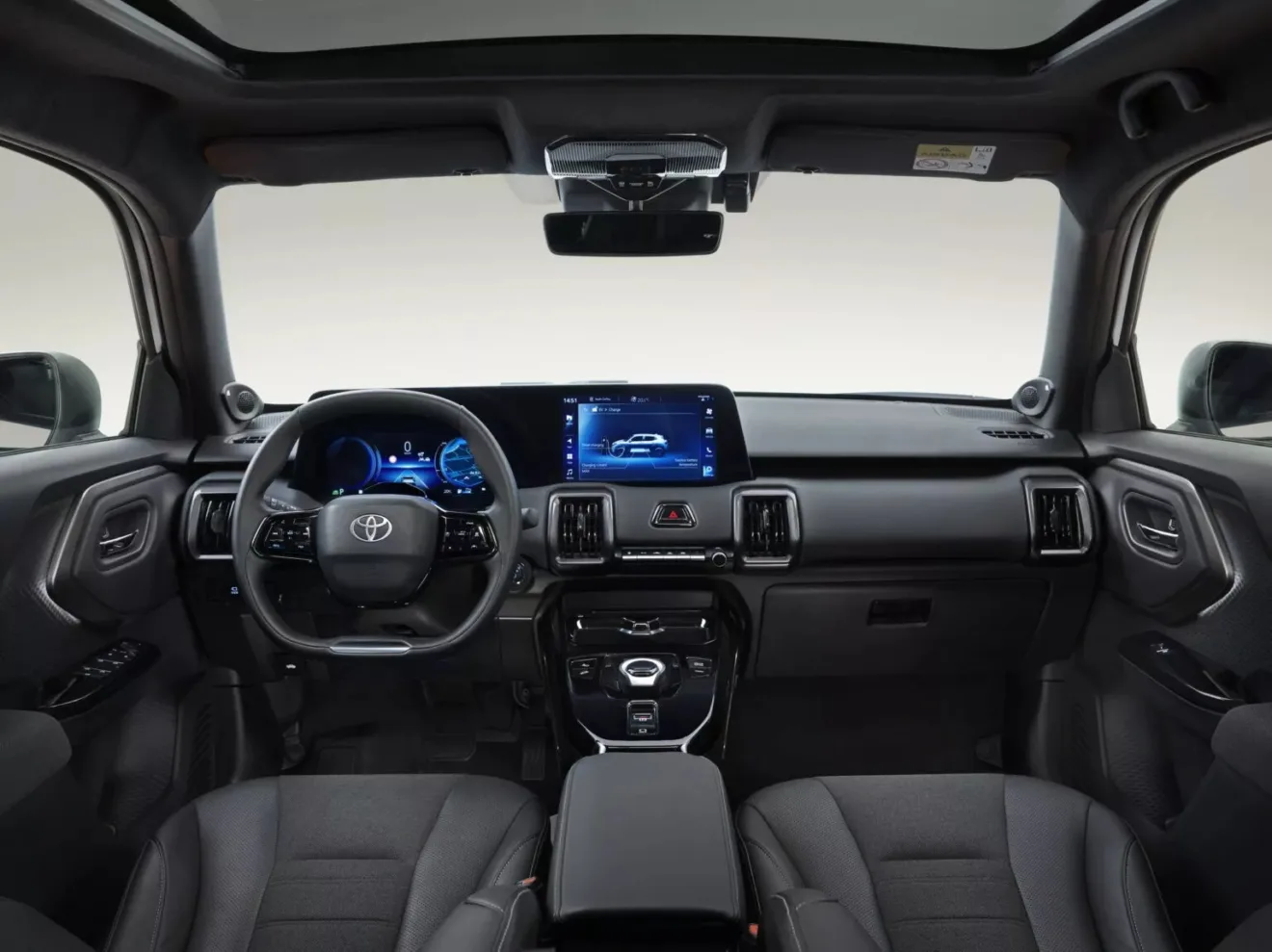 Interior do Toyota Urban Cruiser, com painel de instrumentos e central multimídia ligados e fundo branco