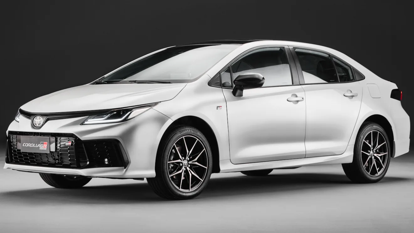 Novo Toyota Corolla GR-Sport 2025 branco, visto de frente e com fundo escuro