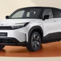 Toyota Urban Cruiser branco com partes pretas, visto de frente, com faróis e DRL's acesos e fundo branco