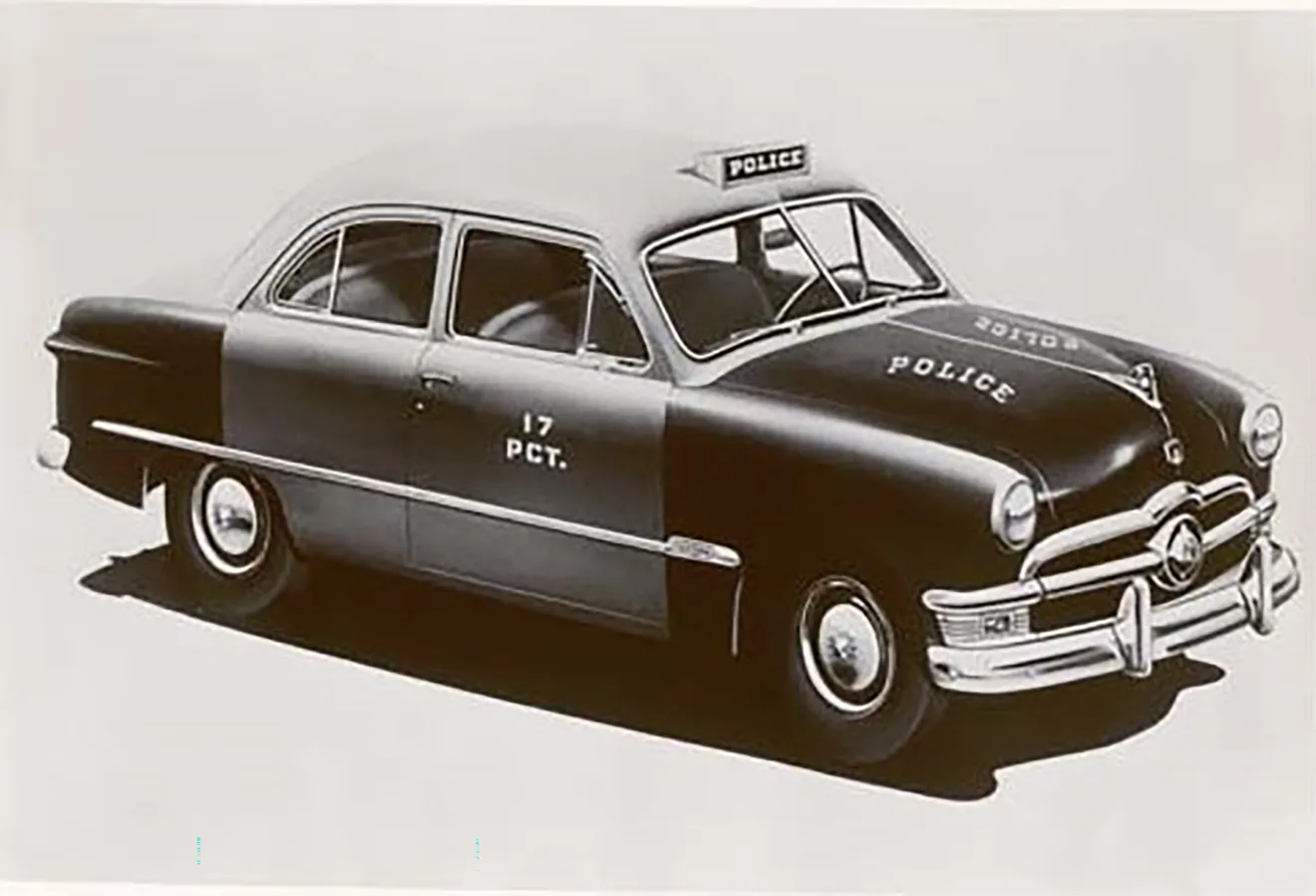 Ford Tudor 1950 como viatura policial parado de frente em foto preto e branco