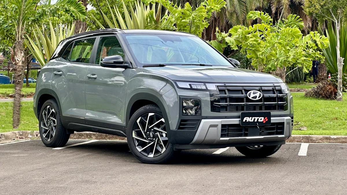 Hyundai Creta Ultimate cinza com teto preto estacionado mostrando a frente com um jardim ao fundo