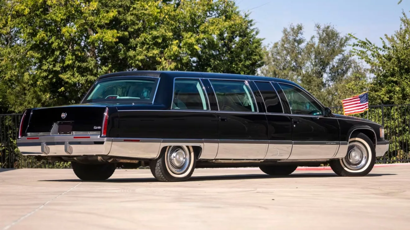 Limousine Cadillac Fleetwood Brougham 1996 de Bill Clinton preto parado de traseira com a bandeira dos Estados Unidos 