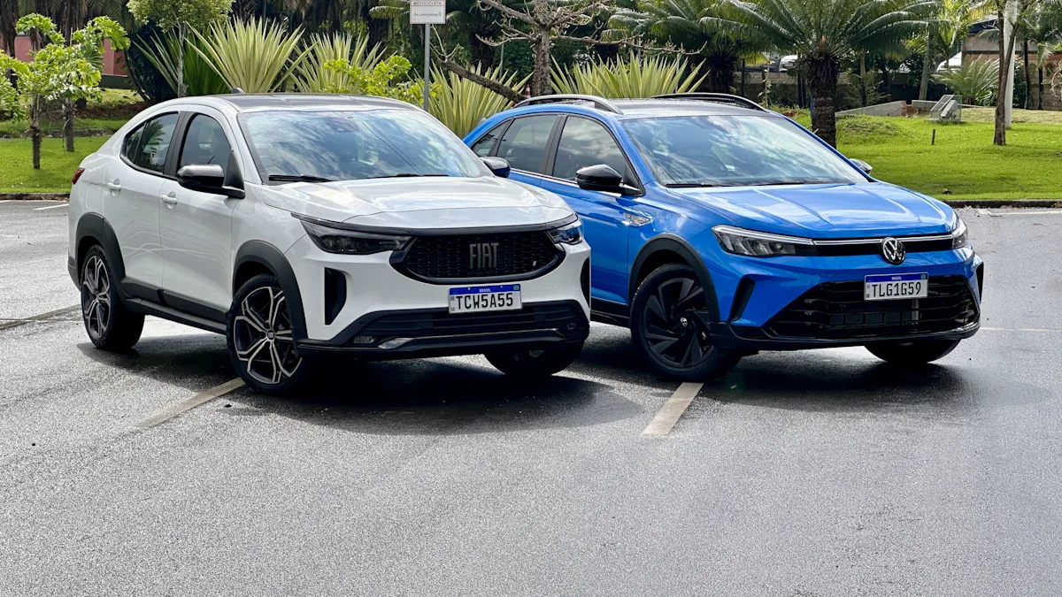 Fiat Fastback Hybrid branco e Volkswagen Nivus Outfit azul de frente em um estacionamento