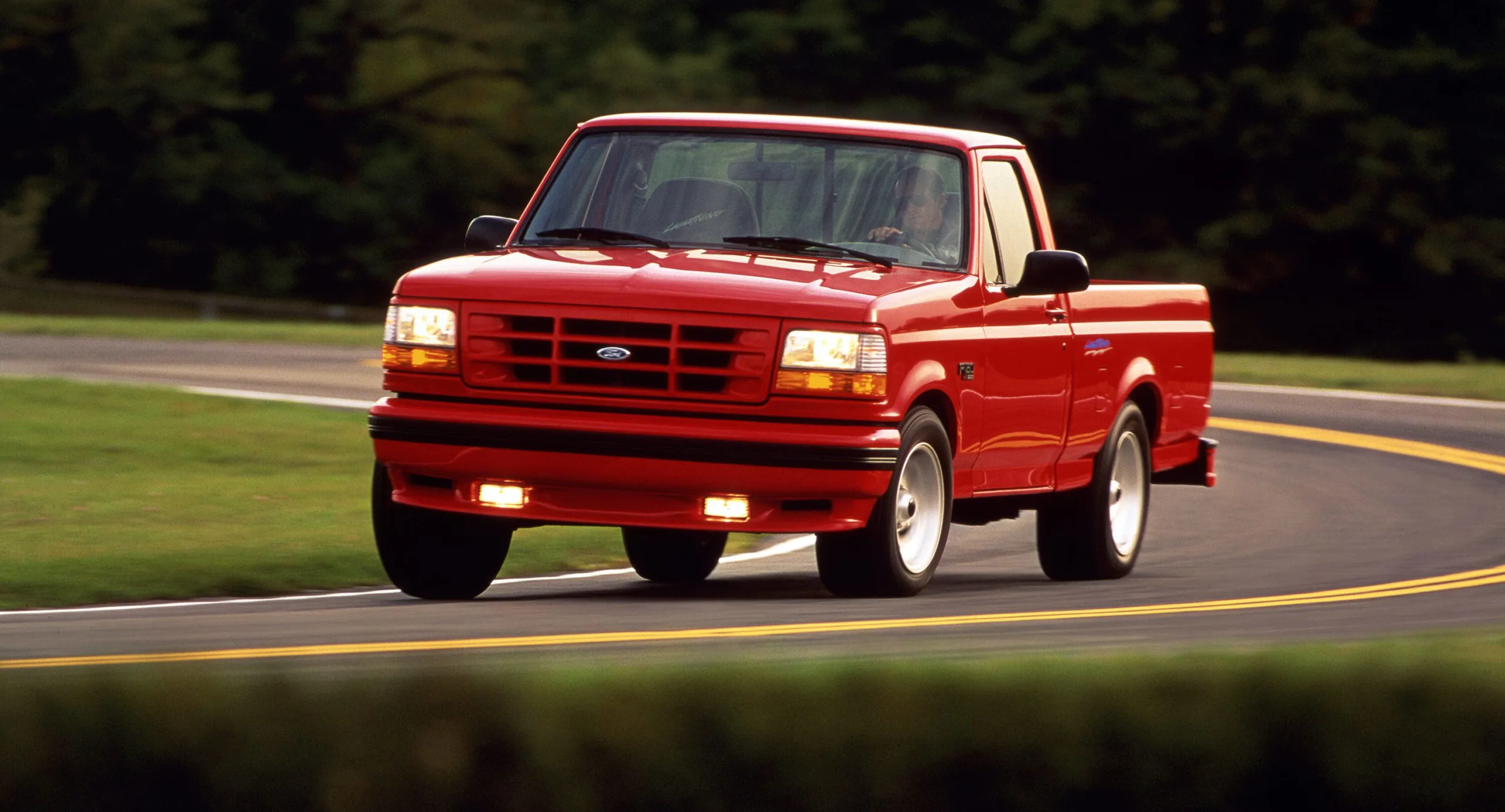 Ford F-150 SVT Lightning vermelha de frente andando na estrada