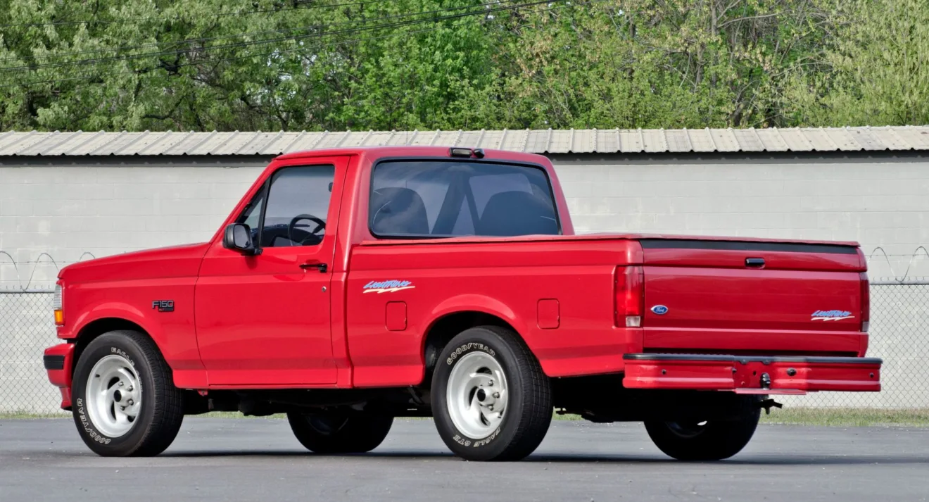 Ford F-150 SVT Lightning vermelha parada de traseira andando na estrada