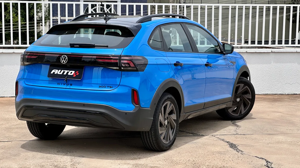 Volkswagen Nivus Highline Outfit azul turbo de traseira com rodas pretas em um estacionamento com prédios ao fundo