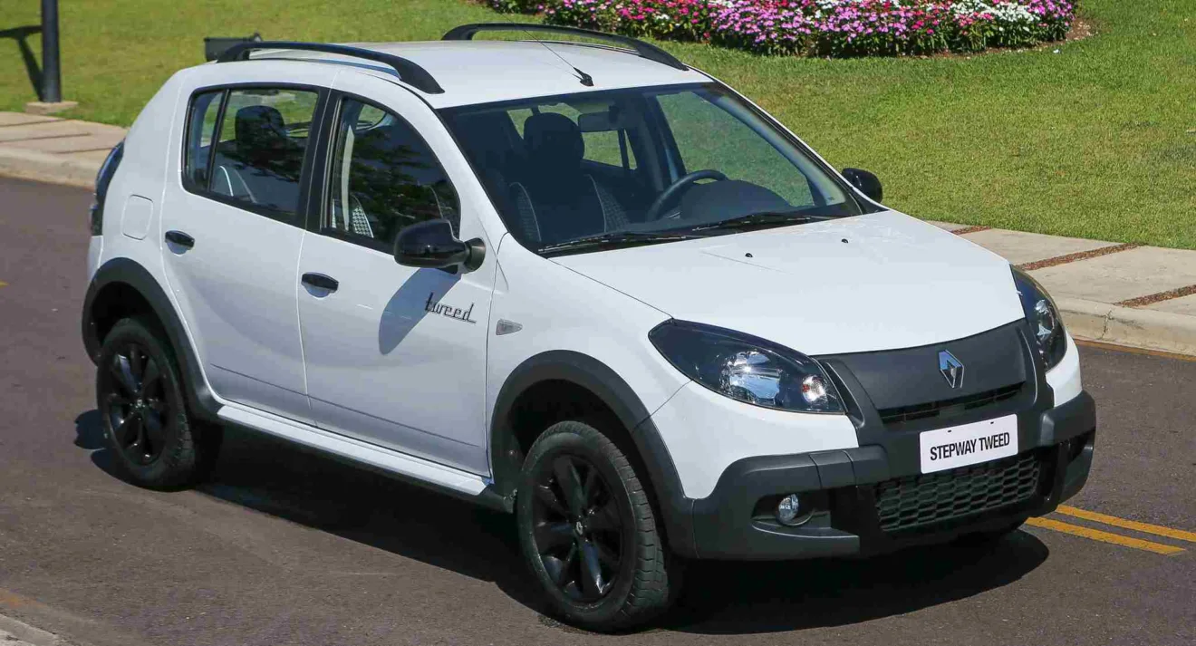 Renault Sandero Stepway Tweed branco parado de frente com flores ao fundo