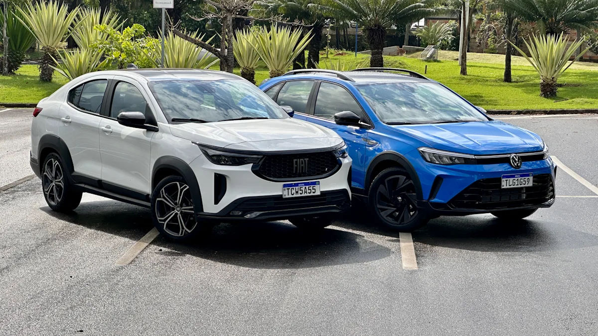 Fiat Fastback Hybrid branco e Volkswagen Nivus Outfit azul de frente em um estacionamento