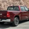 Nova Ram 1500 Laramie parada de traseira com morro ao fundo