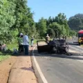 Carro destruído logo após acidente na SC-157, com mato ao redor e caminhão dos bombeiros ao fundo