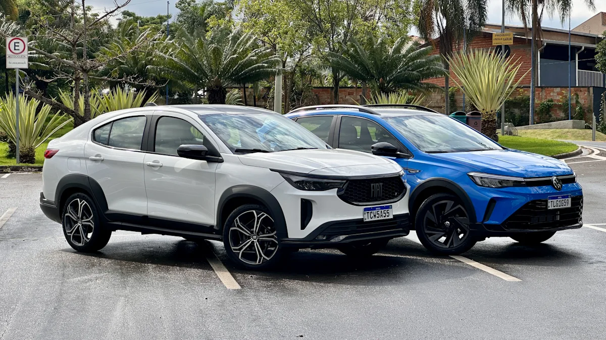 Fiat Fastback Hybrid branco e Volkswagen Nivus Outfit azul de frente em um estacionamento