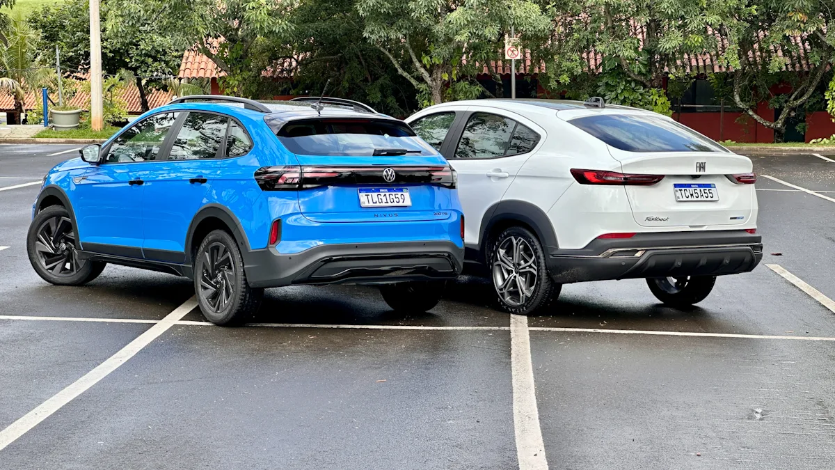 Fiat Fastback Hybrid branco e Volkswagen Nivus Outfit azul de traseira em um estacionamento