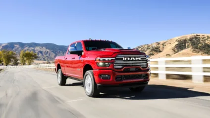 Nova Ram 2500 vermelho de frente andando na estrada com montanha ao fundo