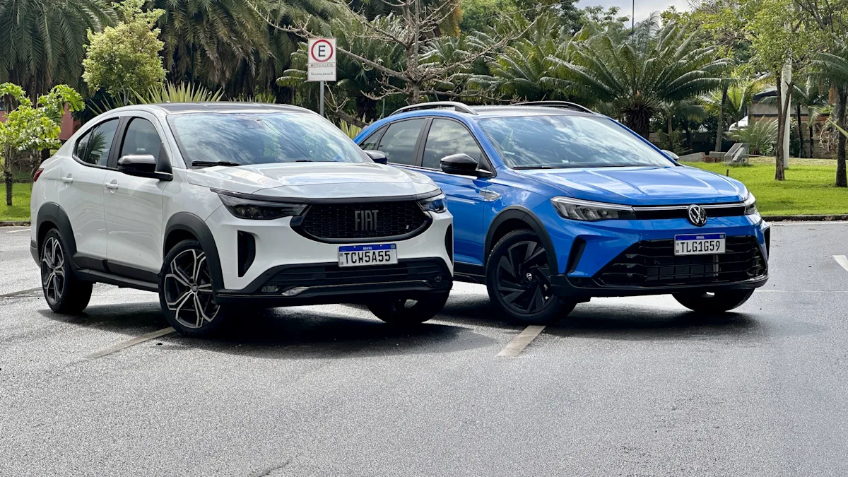 Fiat Fastback Hybrid branco e Volkswagen Nivus Outfit azul de frente em um estacionamento