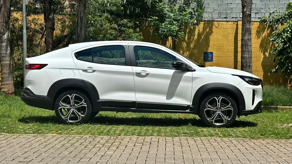 Fiat Fastback Impetus Hybrid parado de lateral com muro amarelo ao fundo