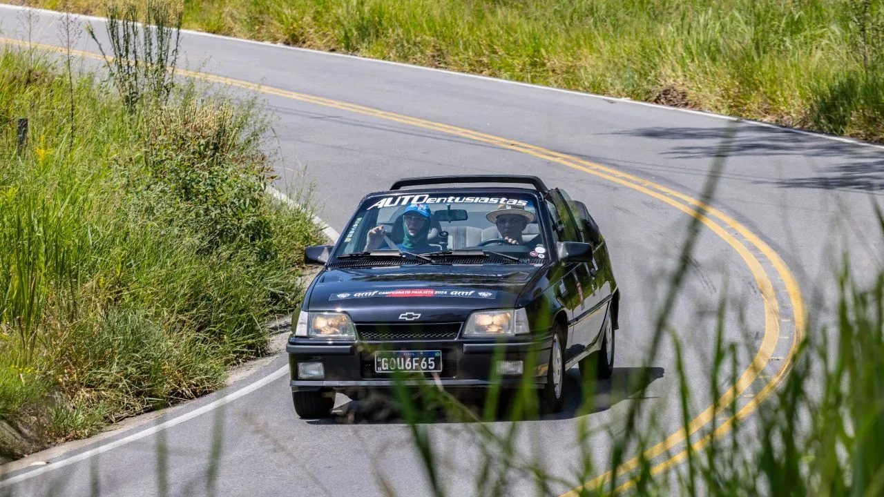 Chevrolet Kadett GSI conversível preto, visto de frente, com faróis acesos em uma pista