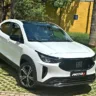 Fiat Fastback Impetus T200 Hybrid branco parado de frente com muro amarelo e árvores ao fundo