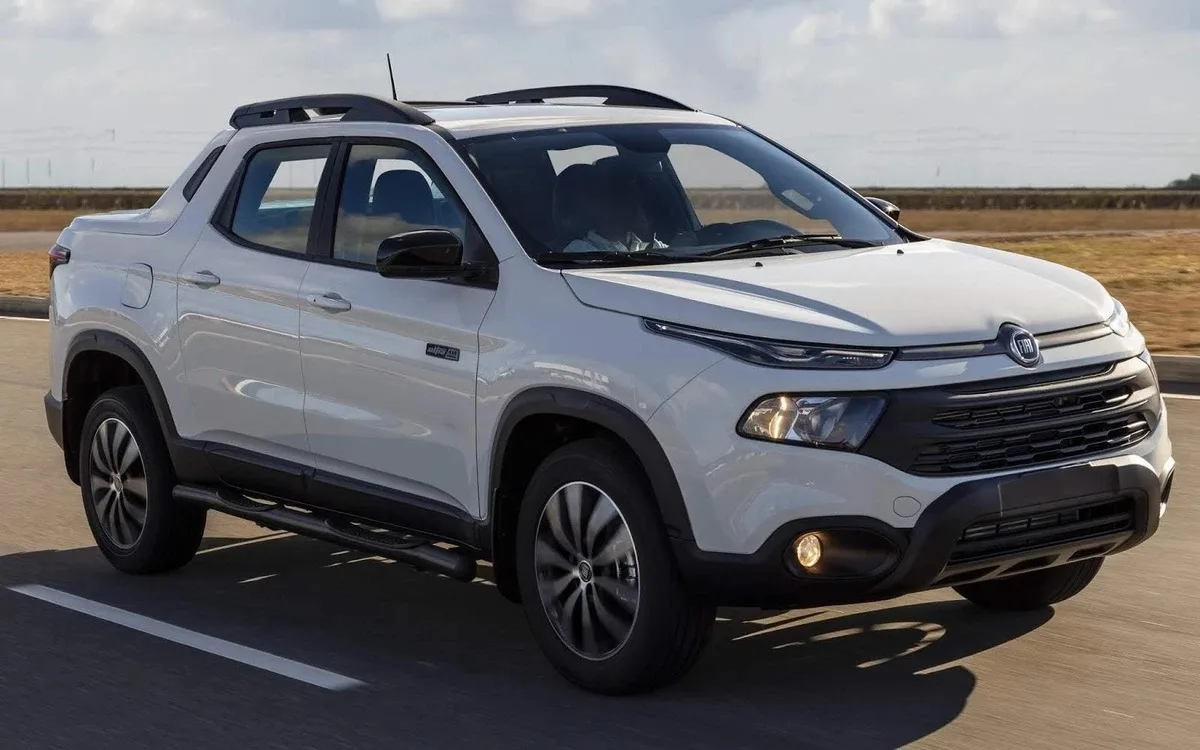 Fiat Toro Ultra branca, com faróis acesos e fundo claro