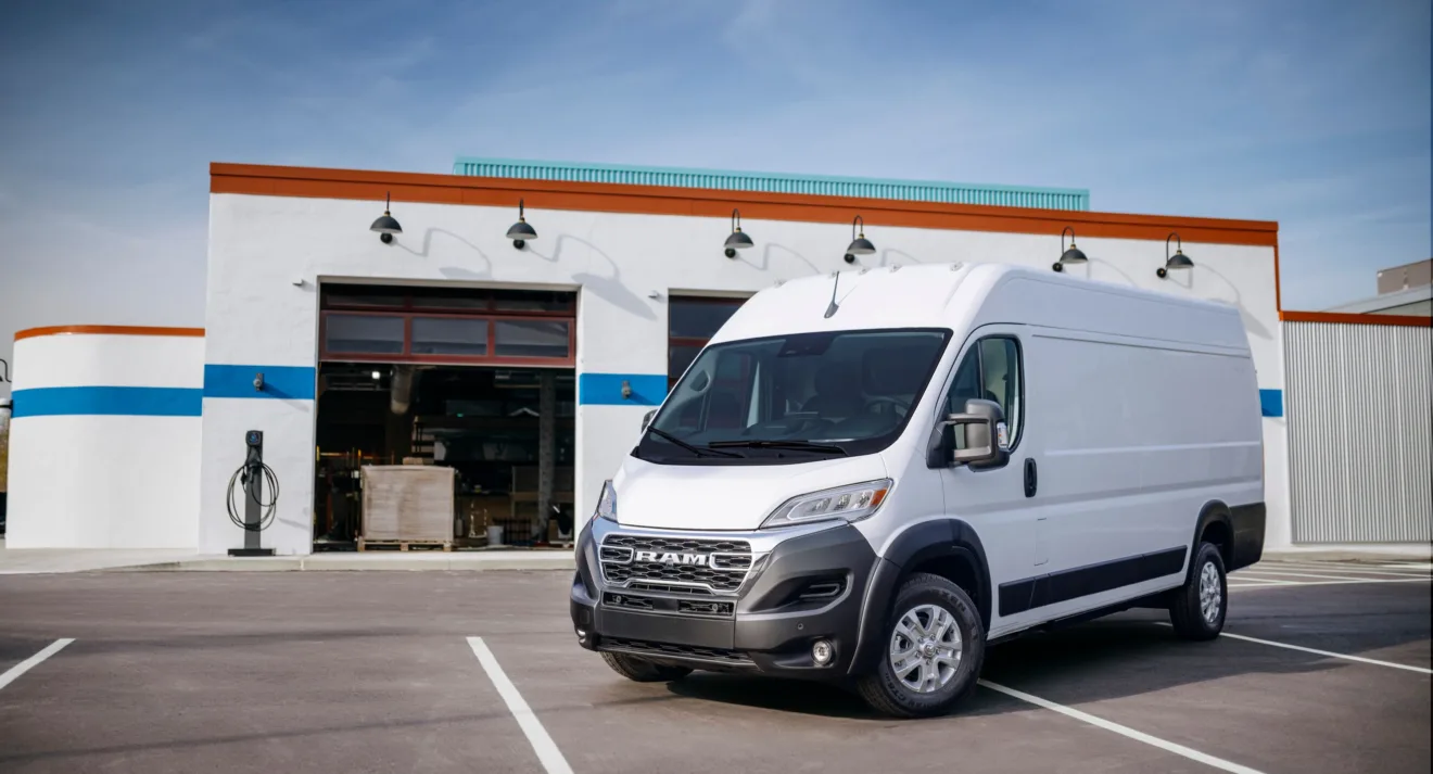 Ram Promaster branca parada de frente com galpão ao fundo