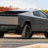Tesla Cybertruck de frente com um muro de plantas vermelhas ao fundo