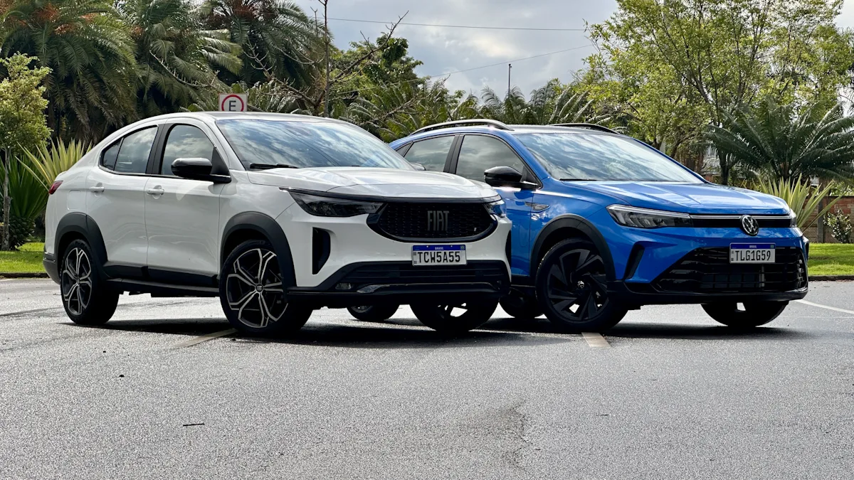 Fiat Fastback Hybrid branco e Volkswagen Nivus Outfit azul de frente em um estacionamento