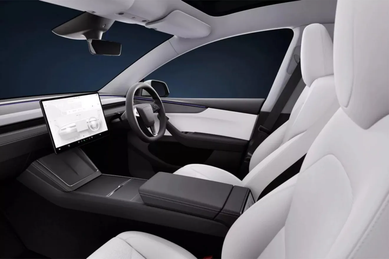 Parte do interior frontal do Tesla Model Y reestilizado com central multimídia ligada, bancos claros e fundo escuro