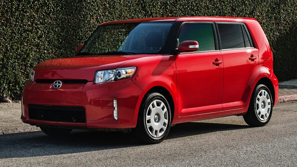 Scion xB de segunda geração vermelho de frente com um gramado ao fundo