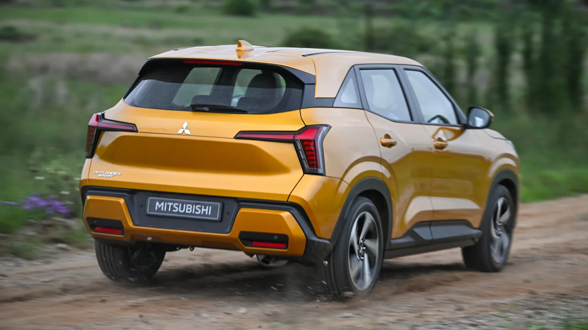 Mitsubishi Outlander Sport amarelo de traseira andando na lama