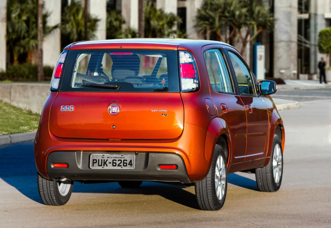 Fiat Uno Evolution com Start-Stop laranja de traseira em movimento