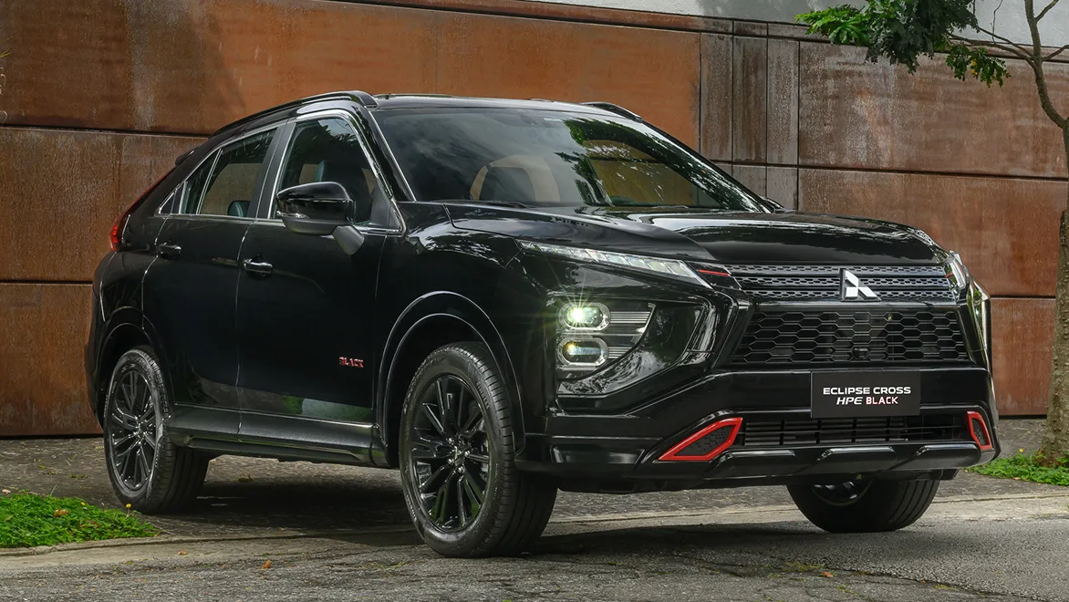 eclipse cross hpe black de frente preto com um muro laranja de fundo