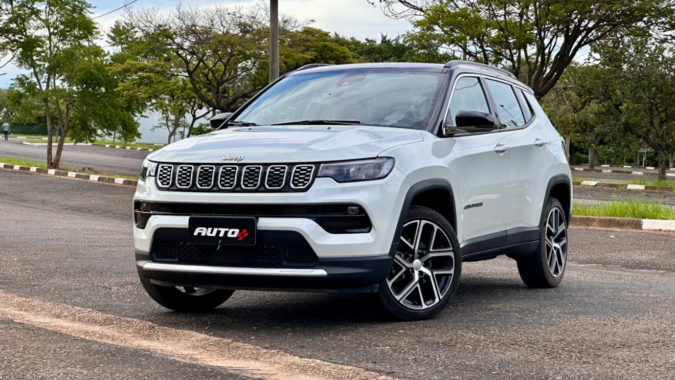 Jeep Compass Limited flex branco com teto preto parado de frente em um estacionamento