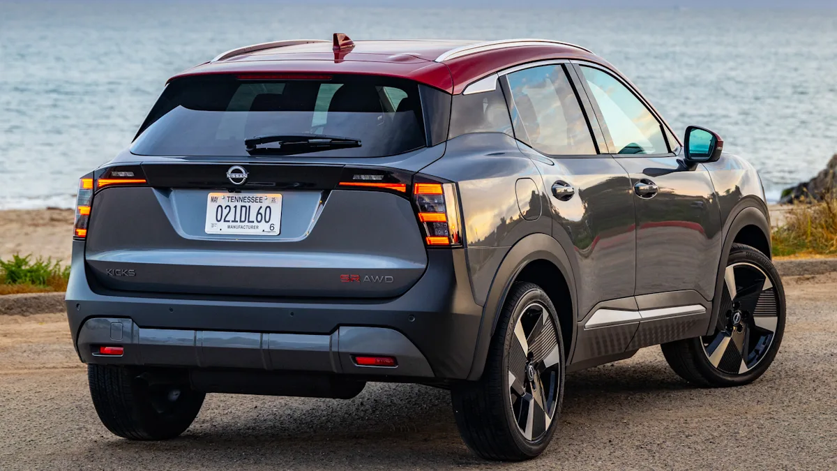 Nissan Kicks de segunda geração cinza com teto vermelho de traseira com lanternas acesas