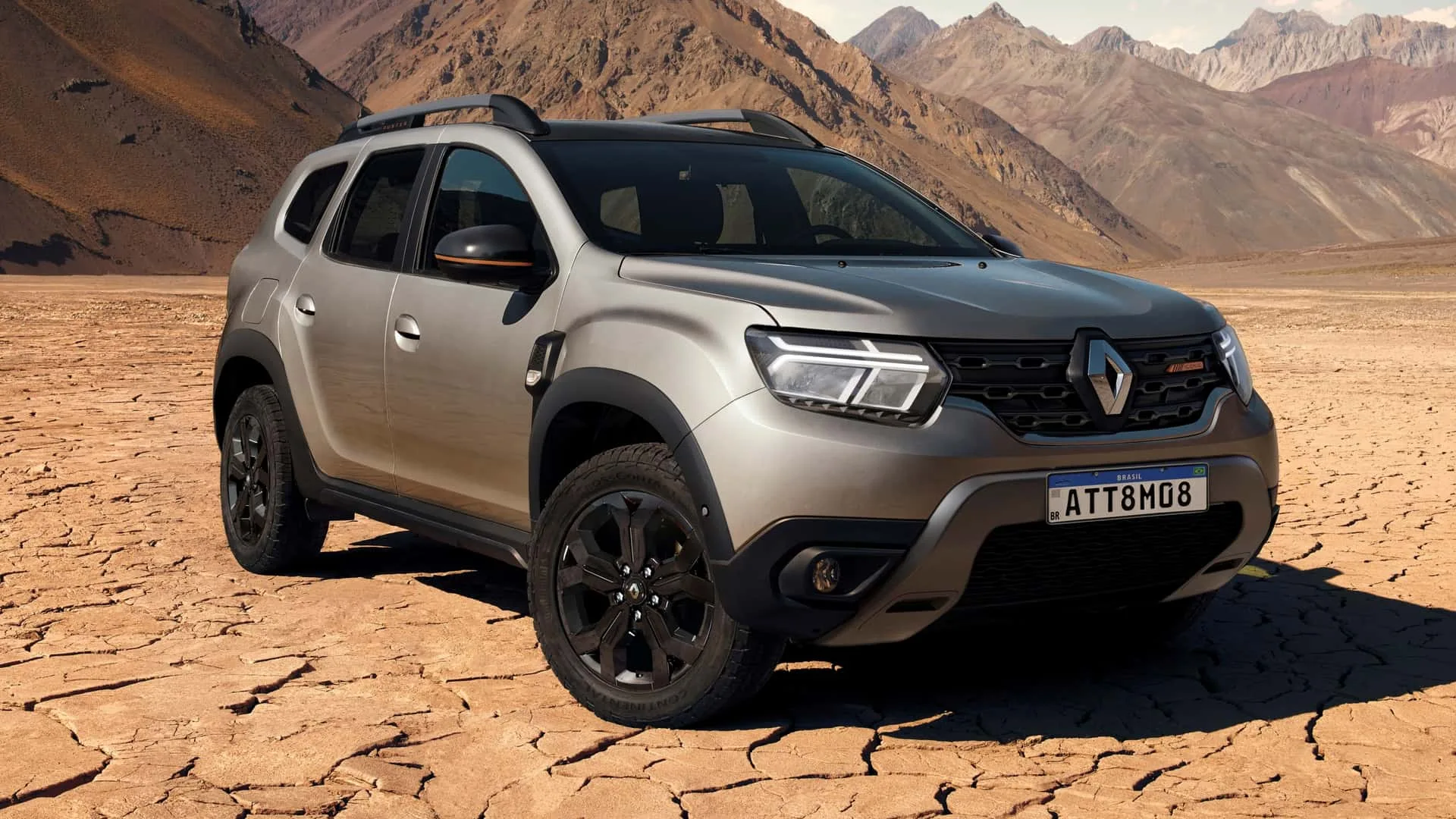 Renault Duster 2026 prata com detalhes pretos, visto de frente e parado em estrada de terra