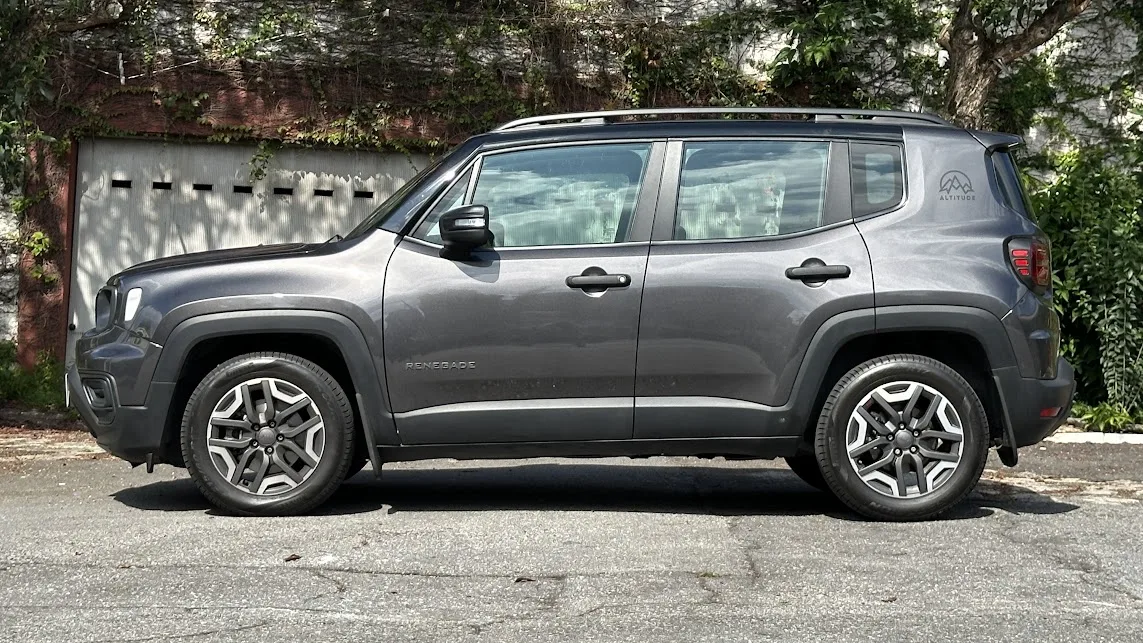 Jeep Renegade Sport Altitude parado de lateral com árvores ao fundo