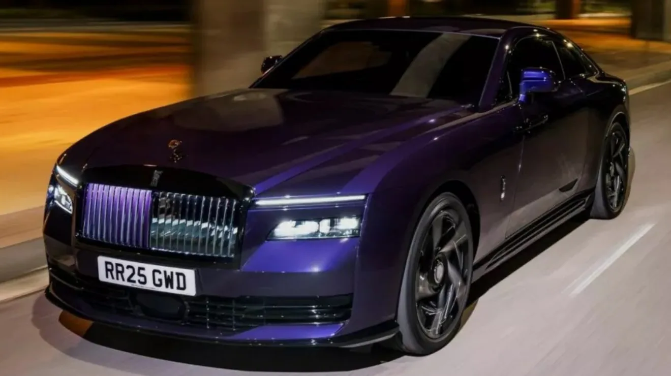 Rolls-Royce Spectre Black Badge roxo com detalhes escuros, visto de frente e com faróis acesos