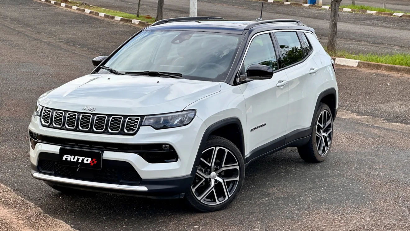 Jeep Compass Limited flex branco com teto preto parado de frente em um estacionamento