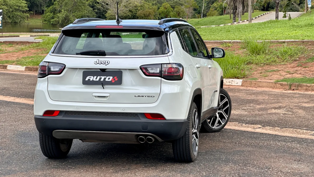 Jeep Compass Limited flex branco com teto preto parado de traseira em um estacionamento