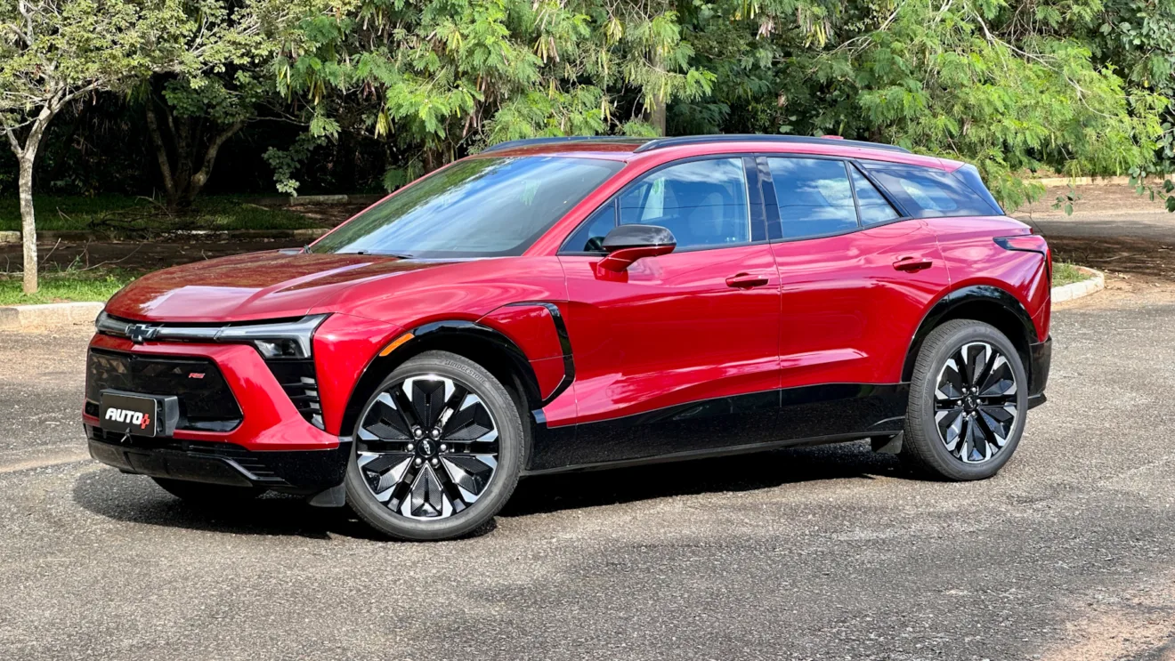 Chevrolet Blazer EV vermelho de lado em um estacionamento com árvores ao fundo