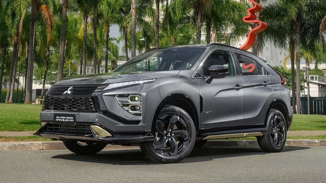 Mitsubishi Eclipse Cross HPE-S Black 4x4 cinza de frente em um parque com um monumento vermelho ao fundo