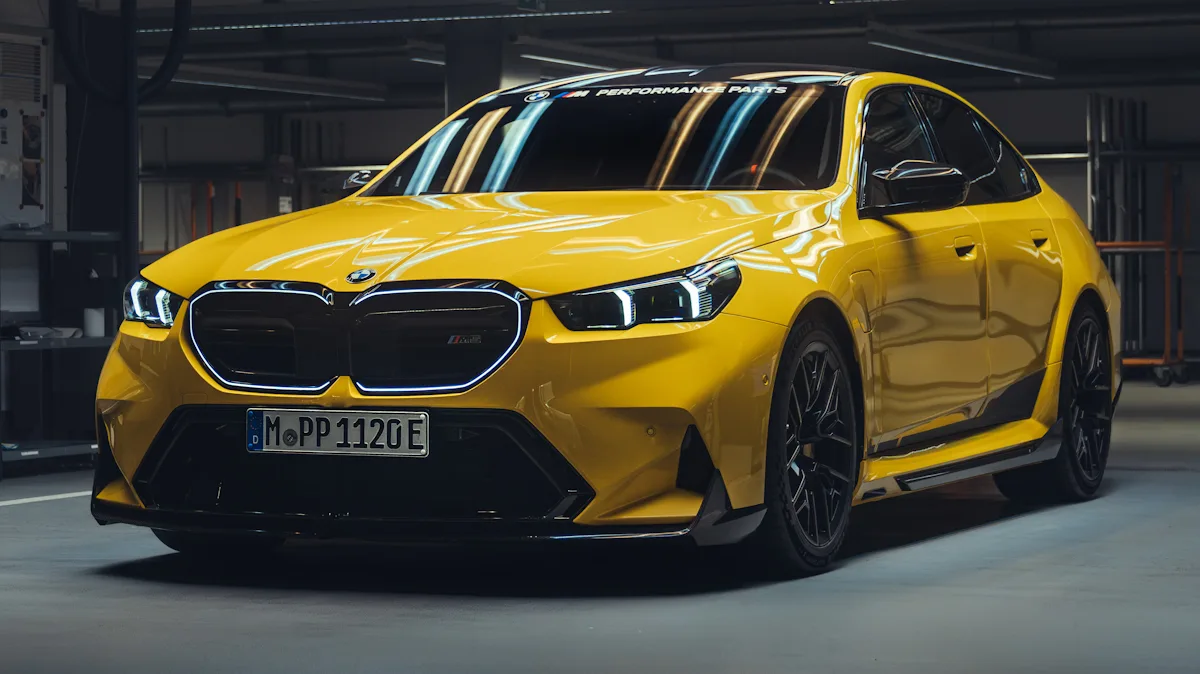 BMW M5 amarelo de frente em um estúdio cheio de luzes