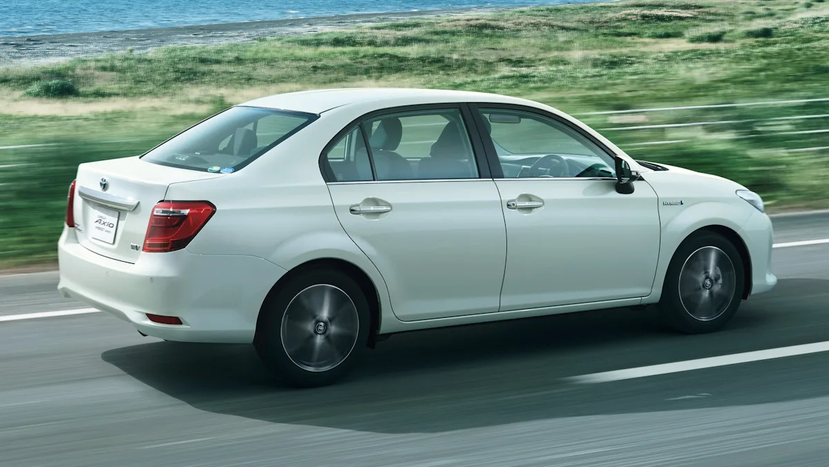 toyota corolla axio de traseira andando em uma rodovia