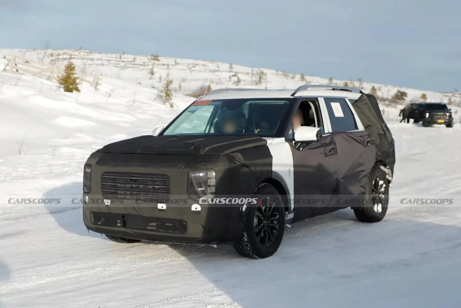 Hyundai Palisade XRT branco camuflado de preto, visto de frente e com neve ao fundo