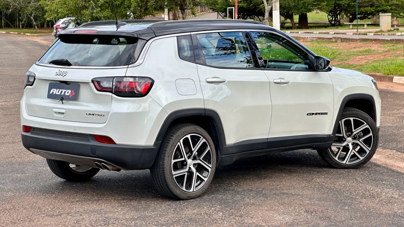 Jeep Compass Limited flex branco com teto preto parado de frente em um estacionamento