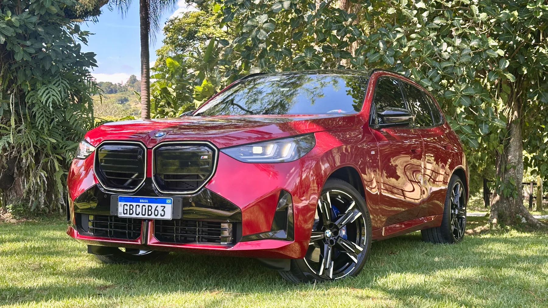 BMW X3 M50 vermelho de frente em um gramado