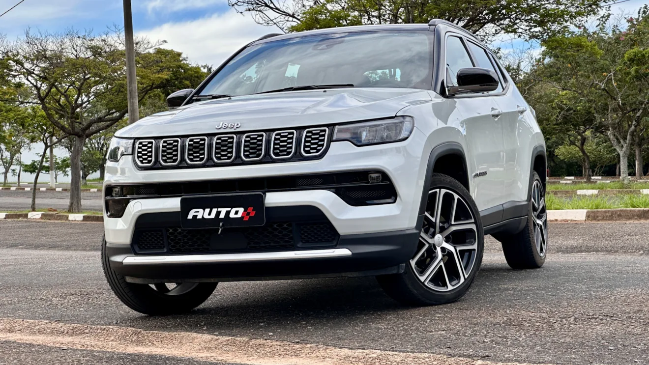 Jeep Compass Limited flex branco com teto preto parado de frente em um estacionamento