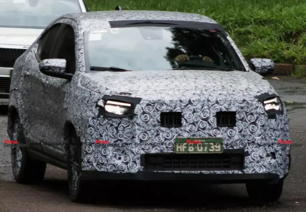 Fiat Fastback reestilizado, camuflado de preto e branco, visto de frente e com faróis acesos