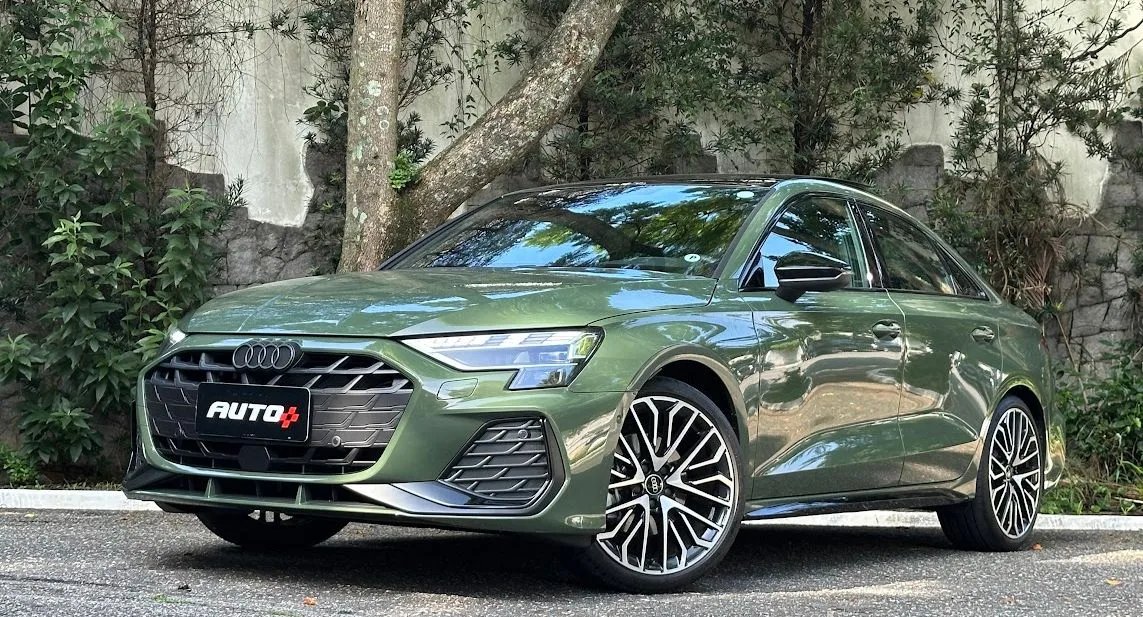 Audi A3 Sedan 2025 verde parado de frente com árvores ao fundo