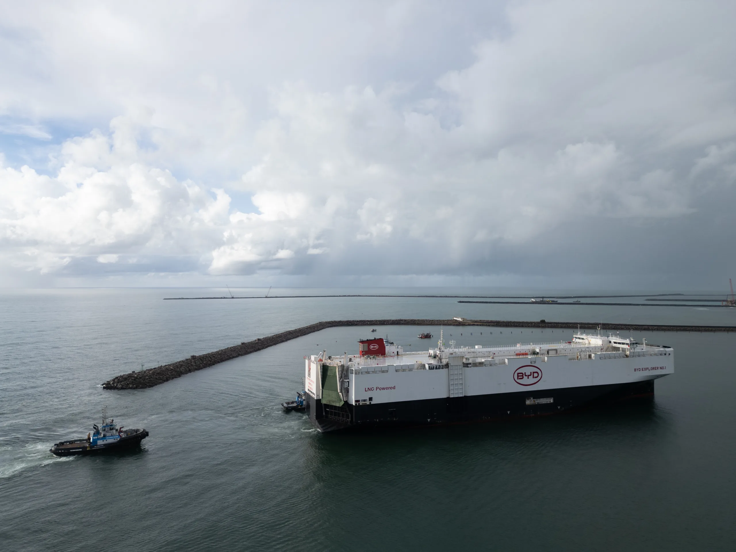 Navio Explorer NO.1 branco com partes pretas e vermelhas da BYD com embarcação atrás