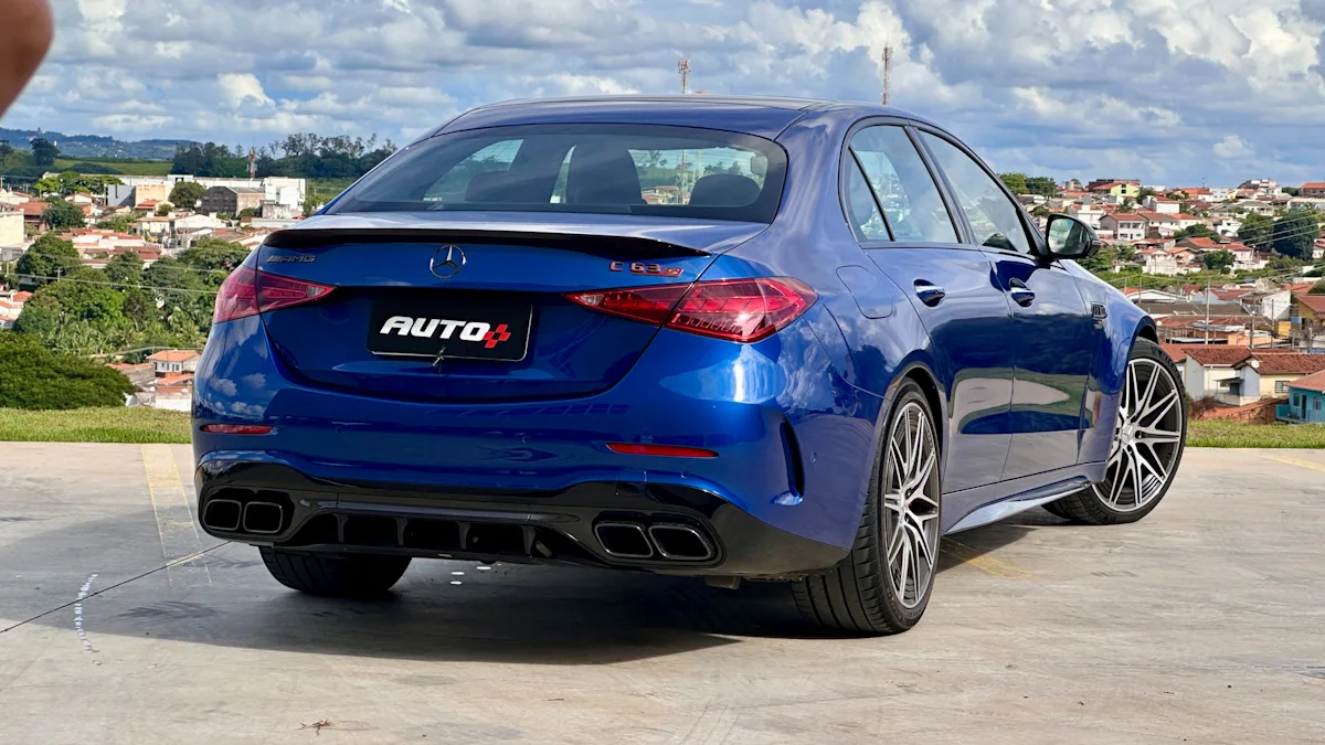 Mercedes-AMG C63 S azul de traseira com uma cidade ao fundo